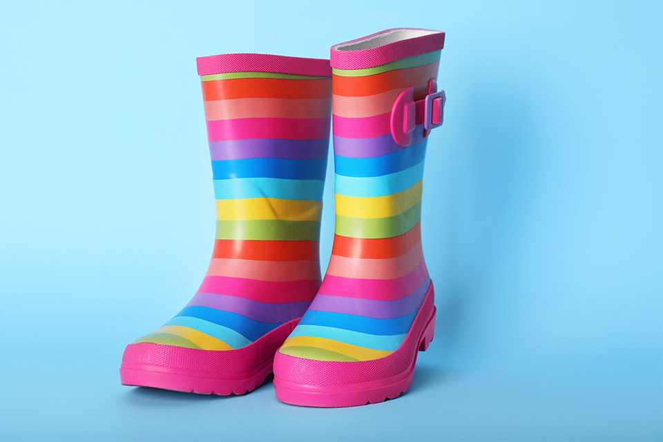Photo of a pair of brightly striped wellington boots on a blue background