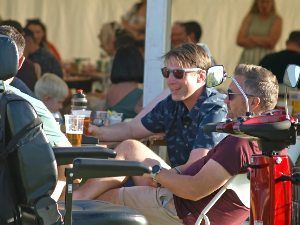 Two men enjoying drinks and chatting outside the marquee at the Parbold Village Show Friday Night Disco 2025.