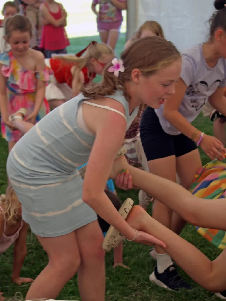 Children helping each other in an energetic team game under the marquee at the Parbold Village Show Friday Night Disco 2025.