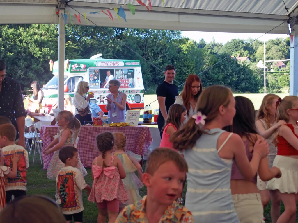 Packed marquee at the Parbold Village Show Friday Night Disco 2025, with children dancing and adults watching on a sunny summer evening.
